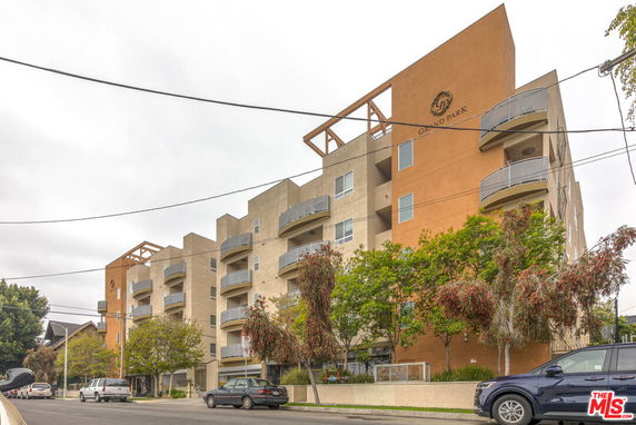 Front view of a multi-story apartment building with balconies and a modern design.