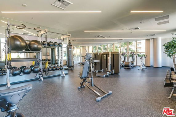 Interior view of a gym area with exercise equipment and weights.