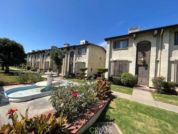 Front view of a multi-story residential building with a garden area.