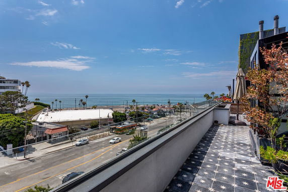 Panoramic view from a building overlooking a coastal area with the ocean in the distance.