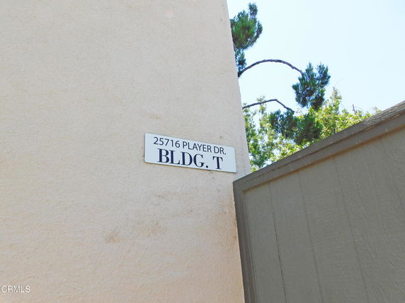 Close-up view of a building corner with a sign indicating Building T at 25716 Player Dr.