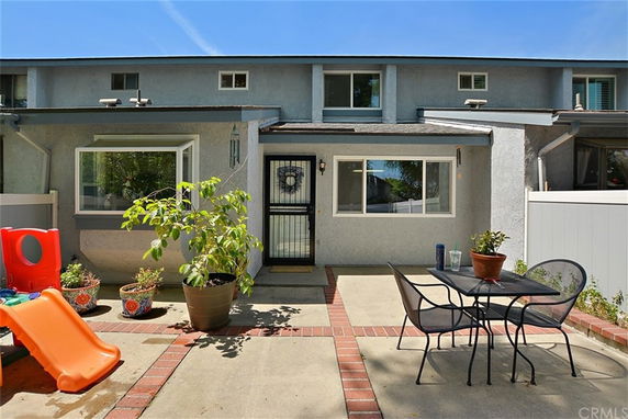 Front view of a two-story house with a patio area.
