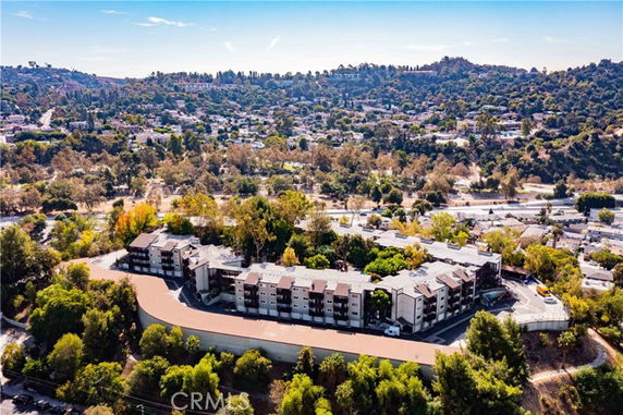 Panoramic view of residential buildings surrounded by trees and hills.