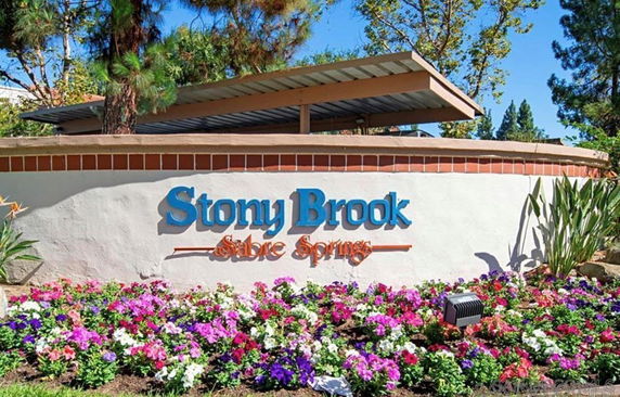Sign for Stony Brook community with landscaped flowers.
