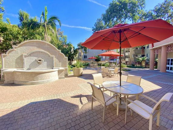 Outdoor seating area with umbrellas and a decorative wall feature.