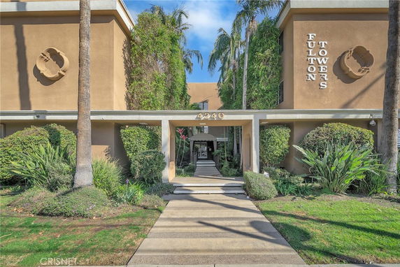 Front view of a multi-story building named Fulton Towers with entrance pathway.
