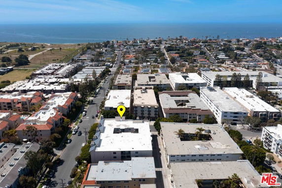 Aerial view of a coastal urban area with multiple buildings and the ocean in the background.