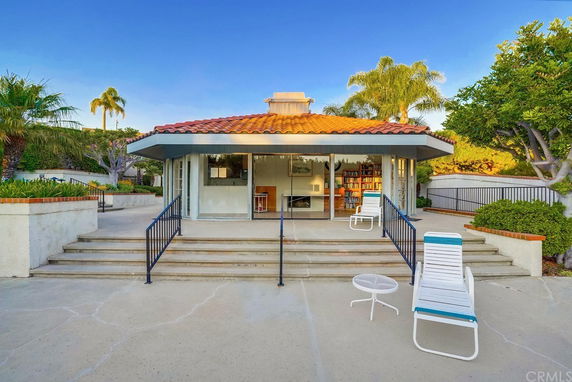 Front view of a house with a tiled roof and large glass doors opening to a patio area.