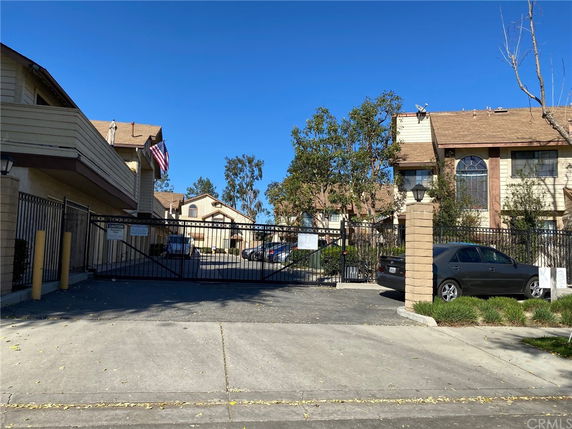 Front view of a gated residential complex with multiple two-story buildings.