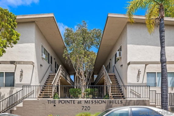 Front view of a two-story apartment complex with central staircase entrance.