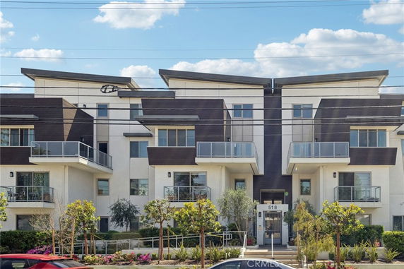 Front view of a modern multi-story building with balconies.