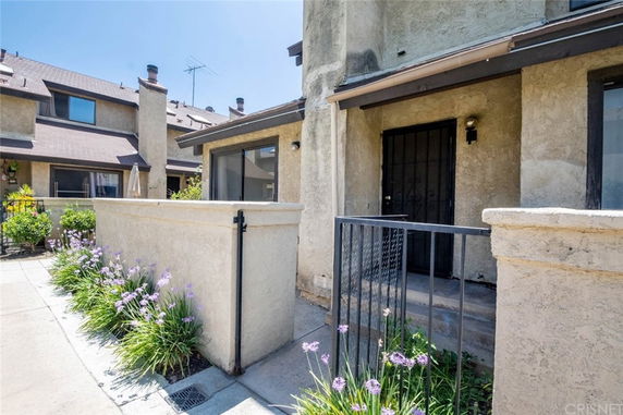 Front view of a townhouse with a small porch and metal railing.