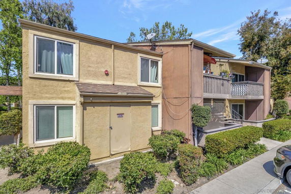 Front view of a two-story residential building with balconies and large windows.