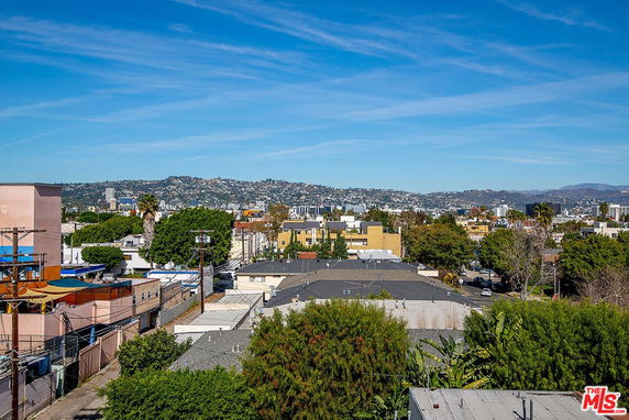 Wide-angle view of a cityscape with hills in the background.
