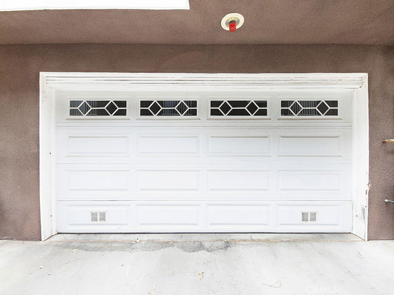 Front view of a house garage door with decorative glass panels.