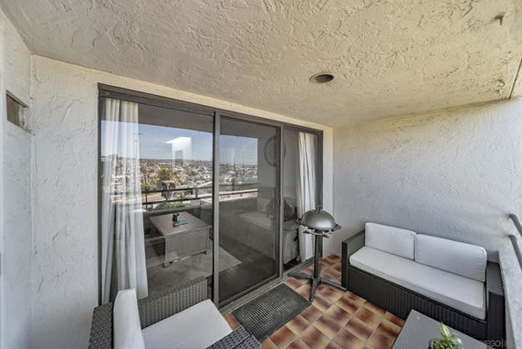 Patio area with seating and a view of the surrounding cityscape.