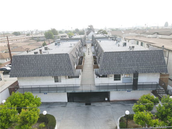 Aerial view of a multi-level apartment building with a central walkway and two symmetrical sections.