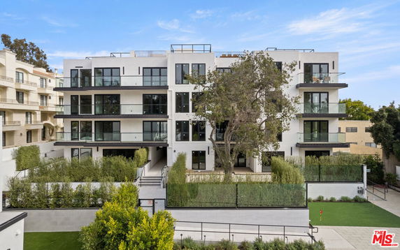 Front view of a multi-story apartment building with balconies.