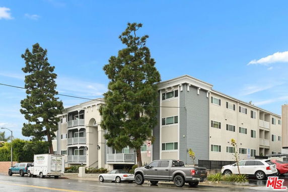 Front view of a multi-story apartment building with balconies.