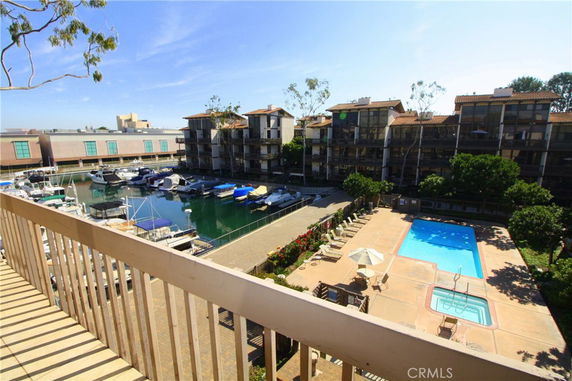 View from a building overlooking a pool and marina with boats docked.