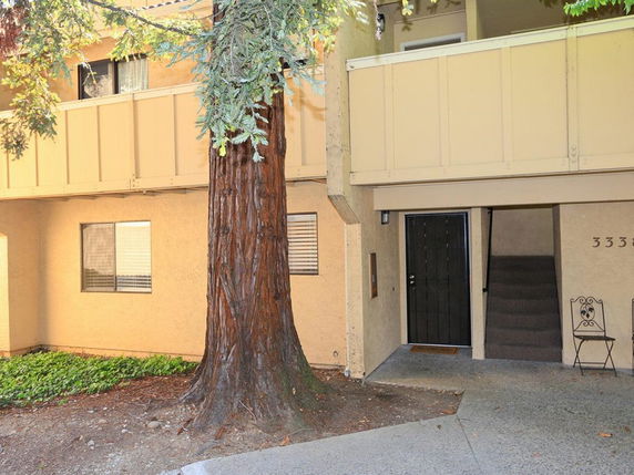 Front view of a two-story apartment building with a staircase entrance.