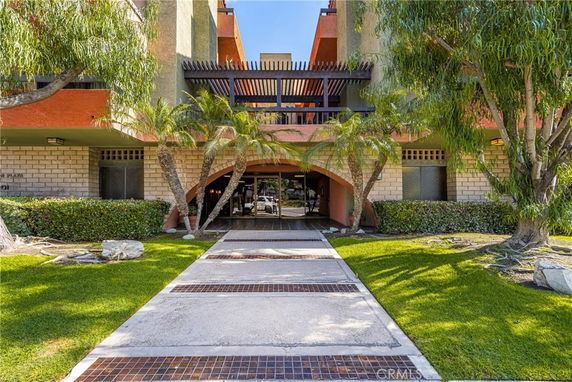 Front view of a multi-story building with a landscaped entryway.