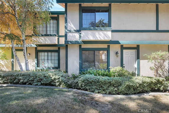Front view of a two-story house with green trim and multiple windows.