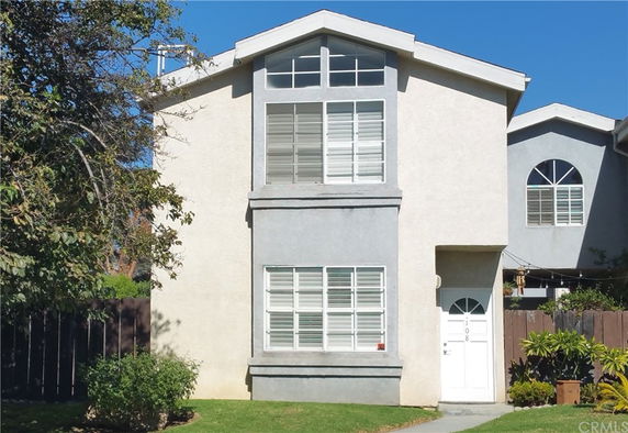 Front view of a two-story house with multiple windows and a single front door.