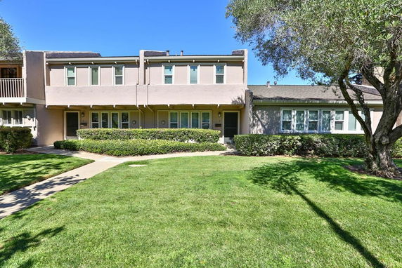 Front view of a two-story residential building with a flat roof and exterior windows.