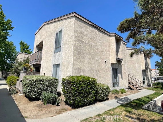 Front view of a two-story apartment building with stairs leading to the second floor.