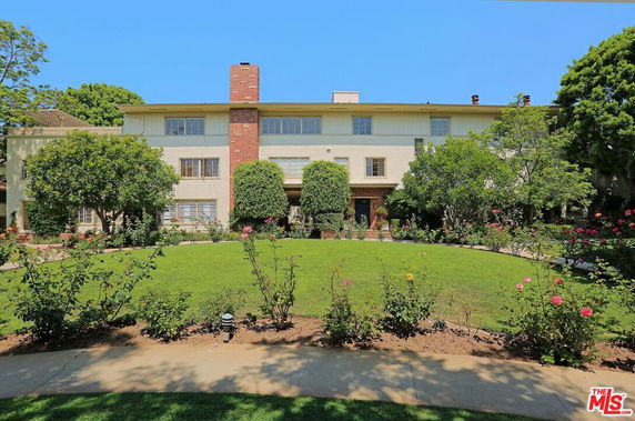 Front view of a multi-story building with a central chimney.