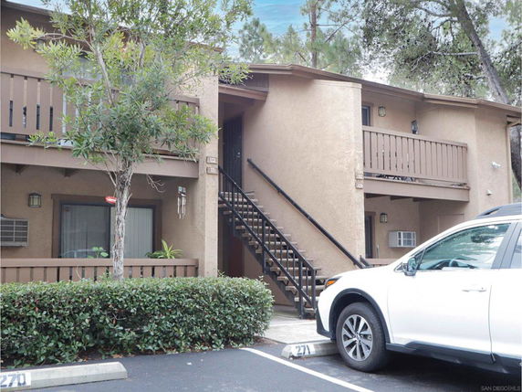 Front view of a two-story apartment building with stairs leading to the upper level.