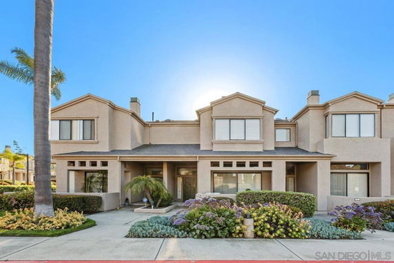 Front view of a two-story townhouse with a symmetrical facade and multiple windows.