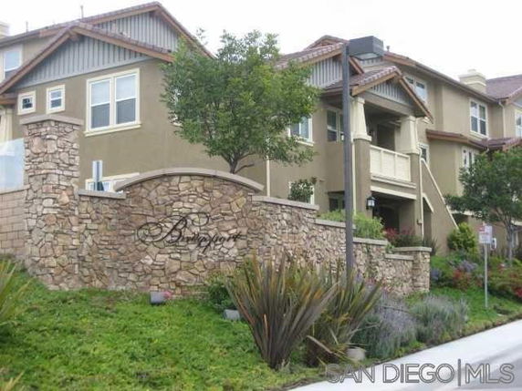 Front view of a multi-story building with stone accents and balcony.