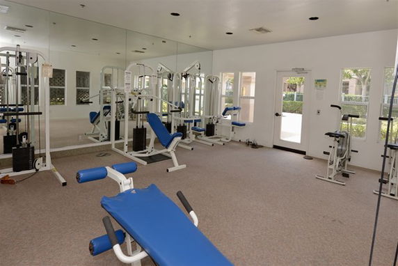 Indoor gym area with exercise equipment including benches and machines.