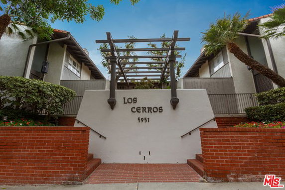 Front view of a building with brick and stucco features, labeled 'Los Cerros 5951'.