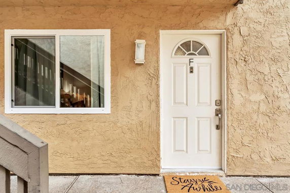 Front view of a building entrance with a white door and a window beside it.