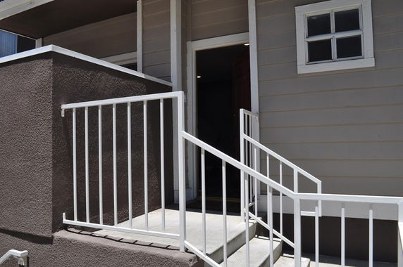Front view of a building entrance with stairs and railings.