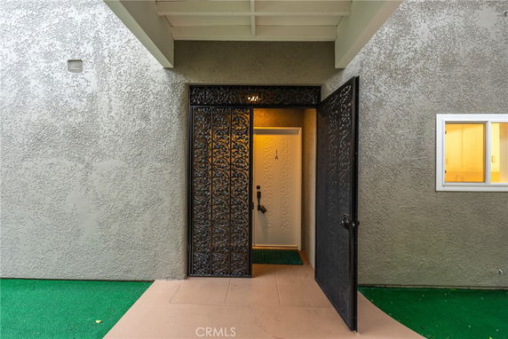 Front view of a building entrance with a decorative metal door.