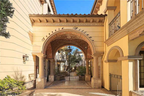 Front view of an arched entrance to a building with ornate details and columns.