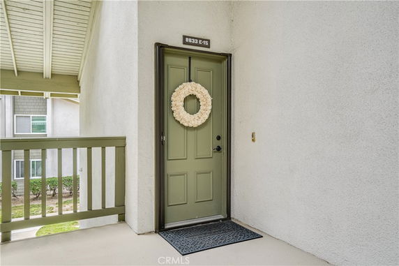 Entryway to a building with a green door and a decorative wreath.