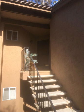 Front view of a two-story building with an external staircase.