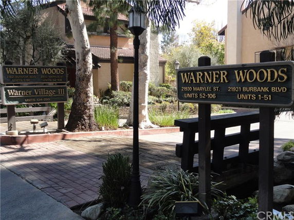 Front view of a residential building complex named Warner Woods with visible signage.