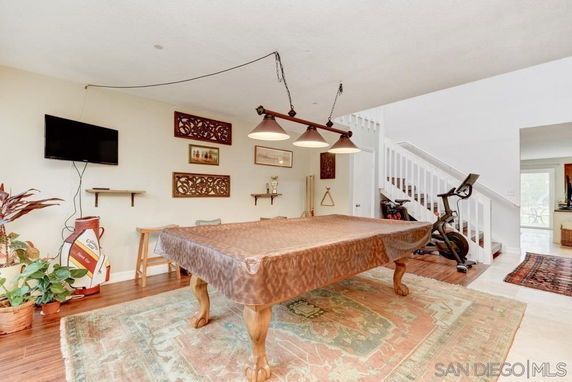 Room with a billiards table and an exercise bike.