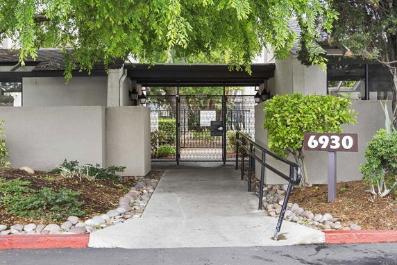 Entrance view of a building with a gated entryway and the number 6930.