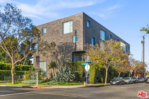 Front view of a modern three-story building with large windows.