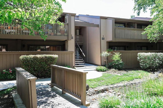 Front view of a multi-story building with a wooden pathway and balconies.