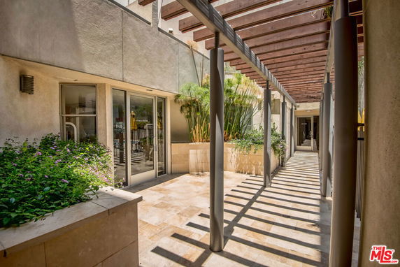 Exterior view of a building with a covered walkway featuring modern design elements.