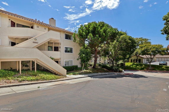 Front view of a multi-story residential building with stairs leading to upper levels.