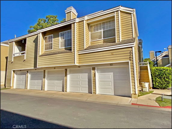 Front view of a two-story building with a row of garages.